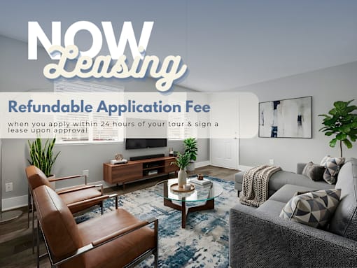 A living room with a sofa, chair, and coffee table with a sign that says "NOW Leasing" and "Refundable Application Fee".