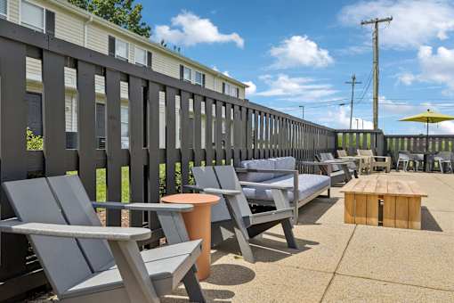 A row of grey chairs are lined up on a patio.