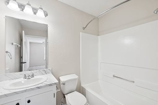 A white bathroom with a toilet, sink, and bathtub.