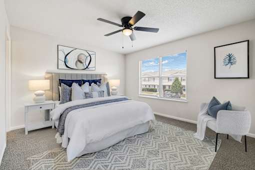 A bedroom with a large bed and a ceiling fan.