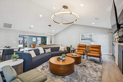 A modern living room with a large sofa, armchairs, and a coffee table.