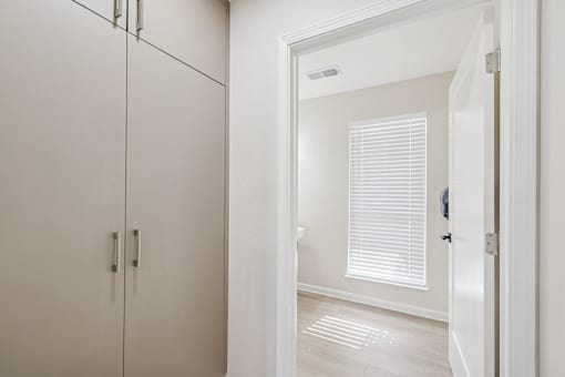 A white bathroom with a white door and a white floor.