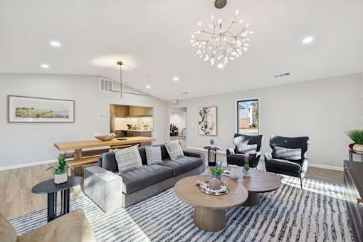 A living room with a grey sofa, a wooden coffee table, and a chandelier.