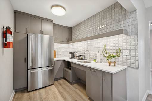 A modern kitchen with a stainless steel refrigerator and a white countertop.