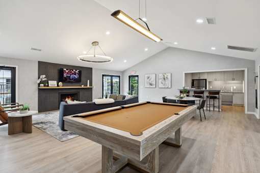 A pool table is in the middle of a living room.