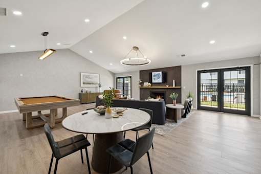 A modern dining room with a pool table and a fireplace.