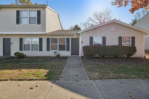 Two houses with a concrete walkway between them.