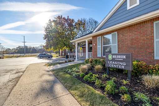 A Holbrook Leasing Center sign is displayed in front of a brick building.