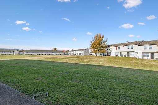 A large grassy field with a building in the background.