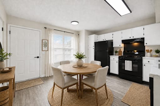 A modern kitchen with a dining table set for two.