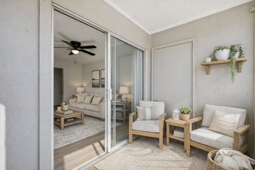A living room with a sliding glass door leading to a balcony.