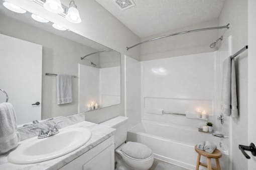 A white bathroom with a toilet, sink, and bathtub.