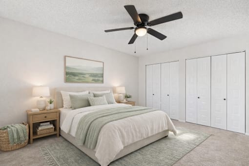 A bedroom with a large bed, a ceiling fan, and a painting on the wall.