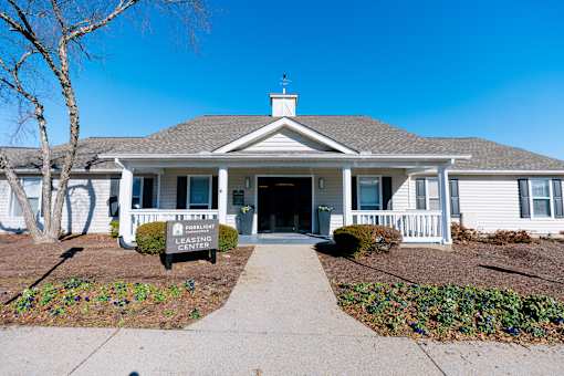A house with a sign that says "Leasing Center" in front of it.