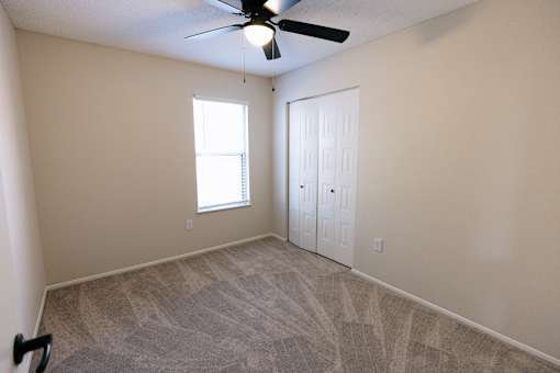 A room with a ceiling fan and a window.