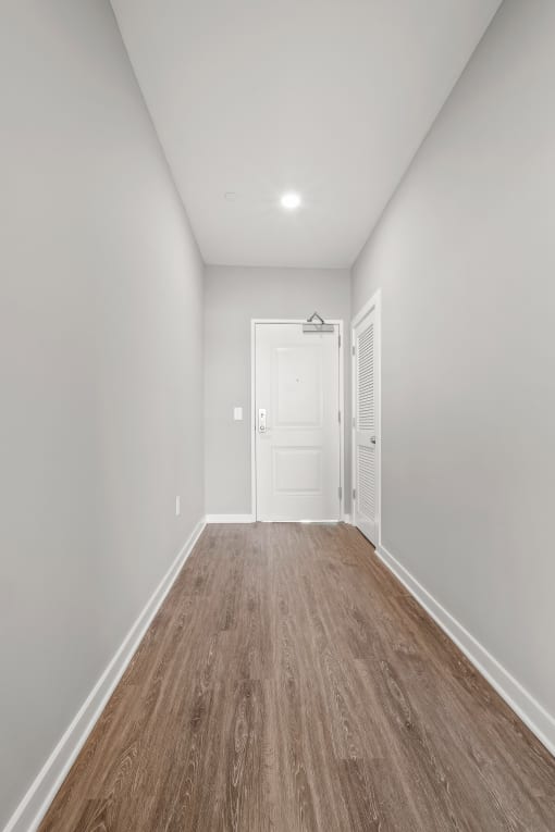 a bedroom with grey walls and a hardwood floor