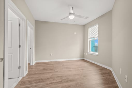 a bedroom with hardwood floors and a ceiling fan