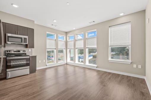 a living room with hardwood floors and large windows