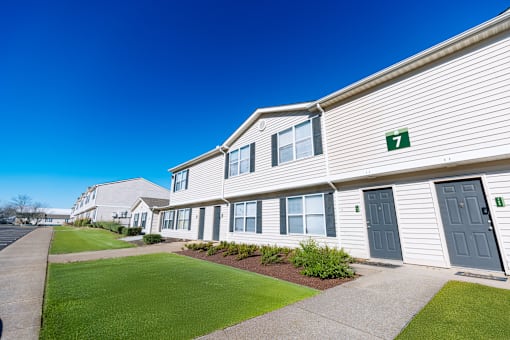 A row of houses numbered in order with green numbers.