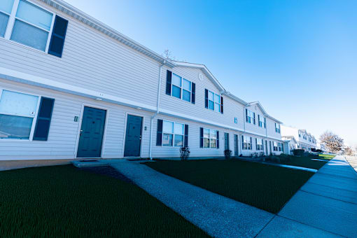 A long white house with a blue sky in the background.