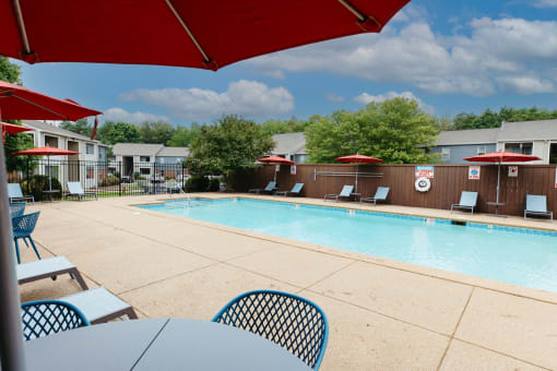 our resort style swimming pool is next to our building with tables and chairs