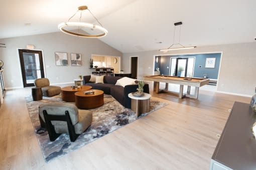 a large living room with a pool table and couches