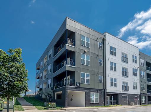 A modern apartment building with a mix of grey and white exterior.