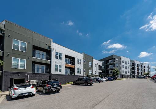 A parking lot with cars and apartment buildings in the background.