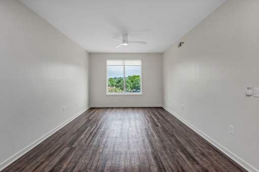 A room with a window and a ceiling fan.
