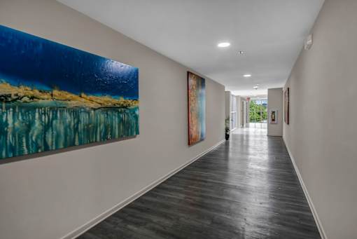 A long hallway with a painting on the wall.