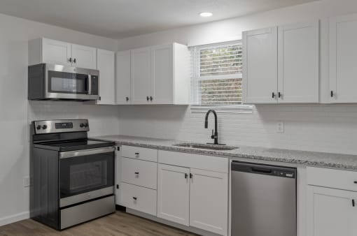 a kitchen with white cabinets and stainless steel appliances and a sink