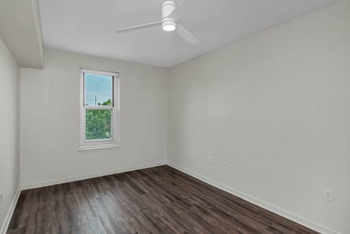 A room with a window and a ceiling fan.