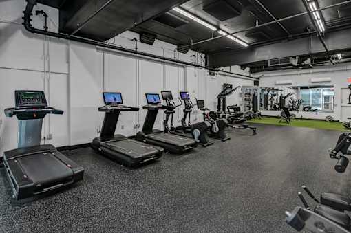 A gym with treadmills and other exercise equipment.
