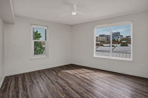 A room with a window and a picture of a cityscape on the wall.