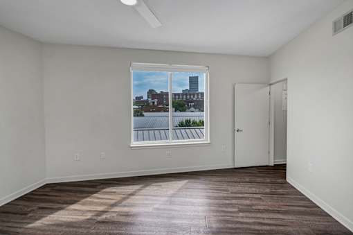 A room with a window showing a view of a cityscape.