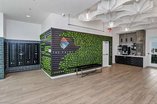 A wall with a green leafy pattern and a logo in the middle.