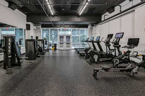 A gym with treadmills and elliptical machines.