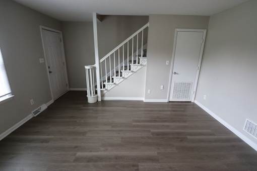 A room with a staircase and white doors.