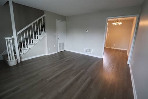 A room with a staircase and wooden flooring.
