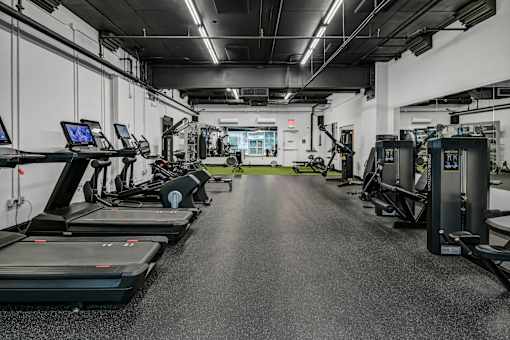 A spacious gym with treadmills, elliptical machines, and other exercise equipment.