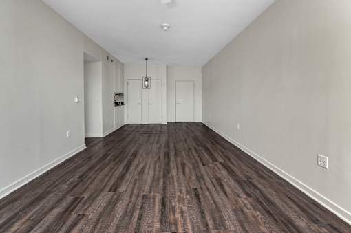 A room with wooden flooring and white walls.