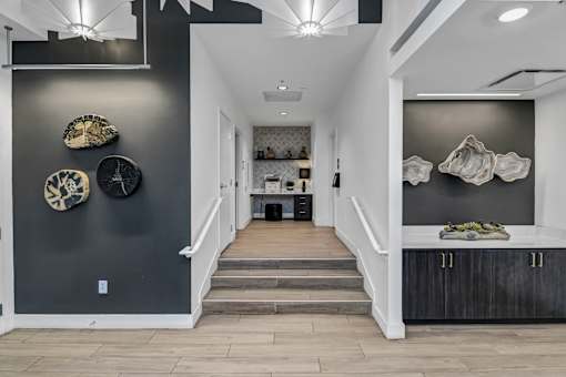 A hallway with a staircase and decorative plates on the wall.