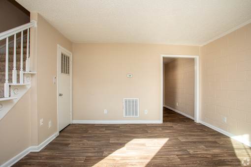 A room with a staircase on the left and a door on the right.