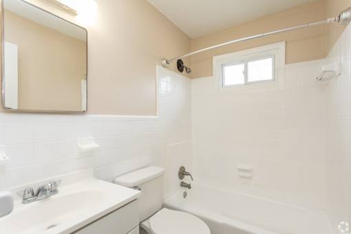 A white toilet sits next to a sink in a bathroom.
