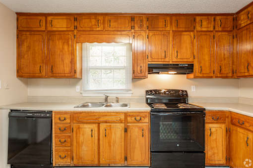 A kitchen with wooden cabinets and black appliances.