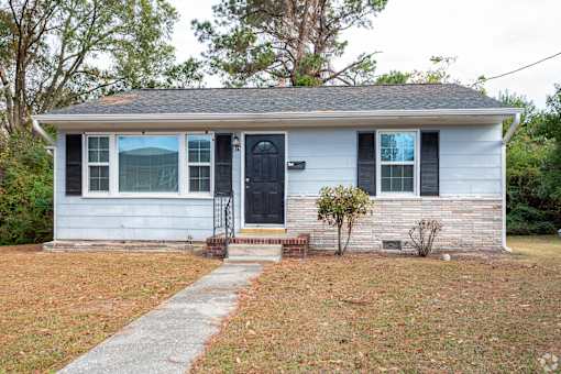 A small house with a black door and a small front porch.