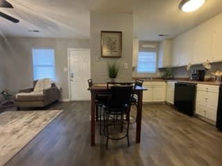 a kitchen and a living room with a table and chairs