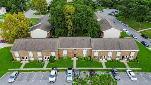 An aerial view of a building with a parking lot in front.