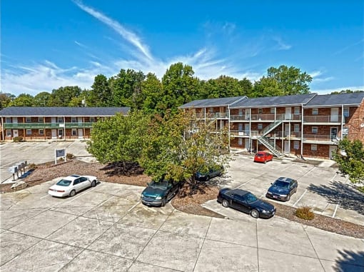 an aerial view of an apartment building and parking lot