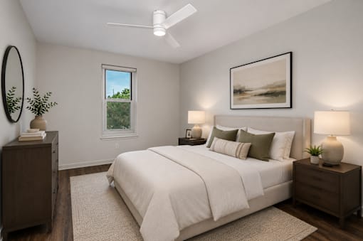 A bedroom with a large bed, a window, and a painting on the wall.